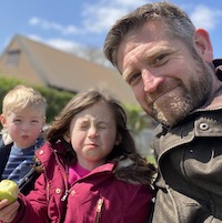 A photograph of Matt, with his two children pulling faces.